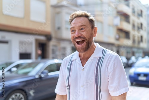 Middle age man standing with surprise expression at street