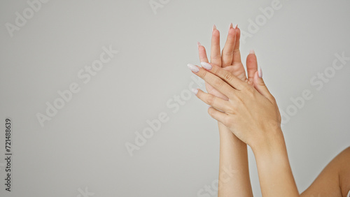Young blonde woman massaging hands over isolated white background