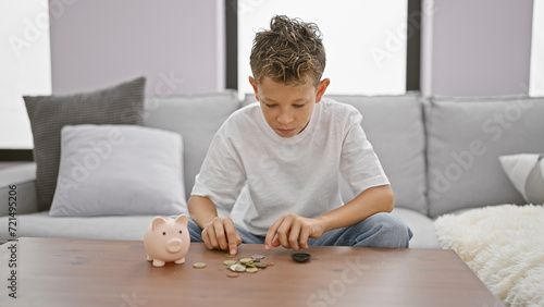 Adorable little blond boy, seriously engaged in counting coins, comfortably sitting on the cozy sofa. indoor relaxation and serious concentration, a valuable lesson in saving and investment at home. photo
