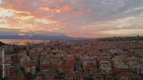 Aerial dolly during sunset of Italian historic city Cagliari (Casteddu, Caralis), Mediterranean Sea, Sardinia, Italy, Europe. Ancient architecture and beautiful scenery. Shot over Monte Urpinu. photo