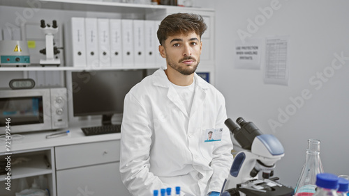 Young arab man scientist using microscope at laboratory
