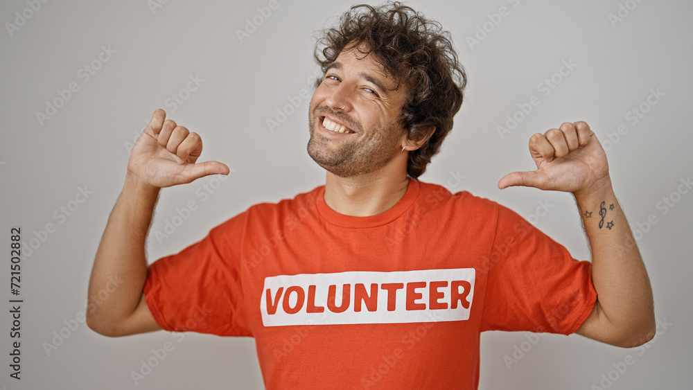 Young hispanic man activist pointing to volunteer uniform smiling over isolated white background Young hispanic man activist pointing to volunteer uniform smiling over isolated white background