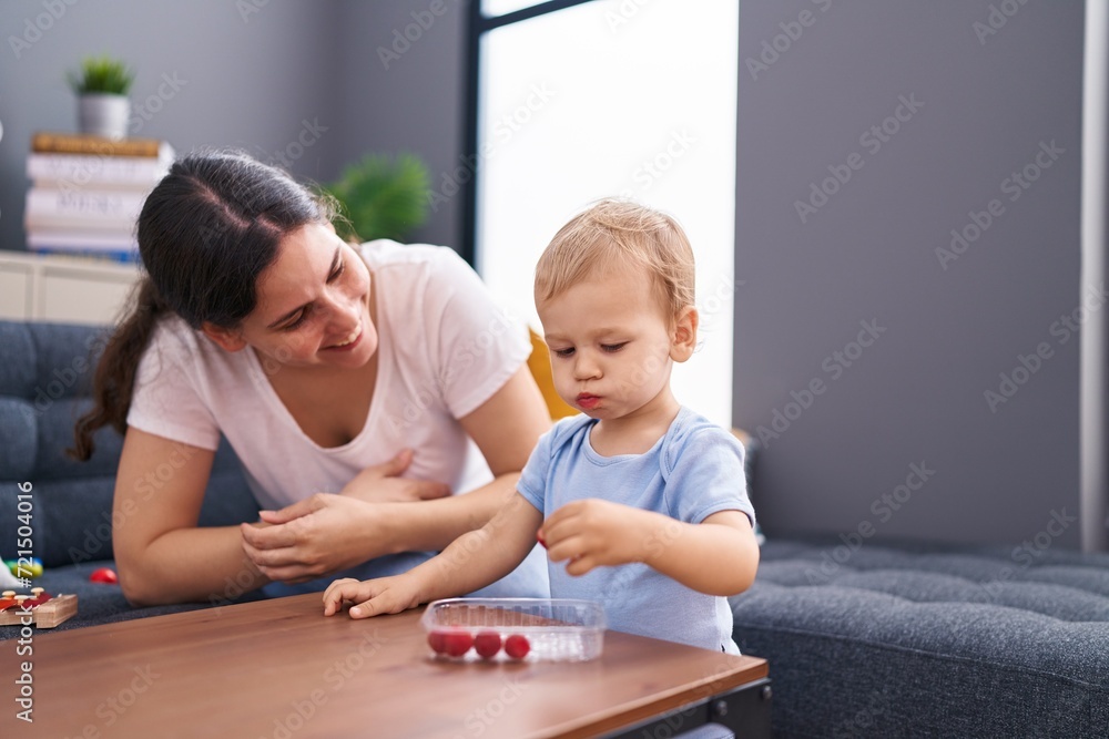 Mother and son smiling confident eating raspberries at home Mother and son smiling confident eating raspberries at home
