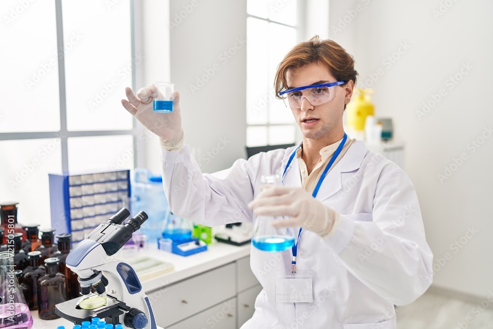 Young caucasian man scientist holding test tubes at laboratory Young caucasian man scientist holding test tubes at laboratory