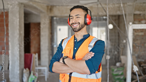 Fotografia Young hispanic man builder with crossed arms wearing noise cancelling earmuffs a