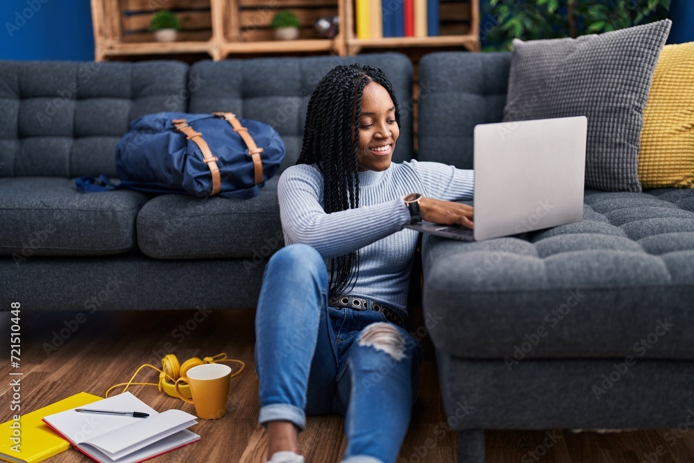 African american woman student sitting on floor using laptop at street African american woman student sitting on floor using laptop at street