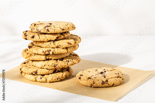 Chocolate chip cookies stacked on white plaster surface

