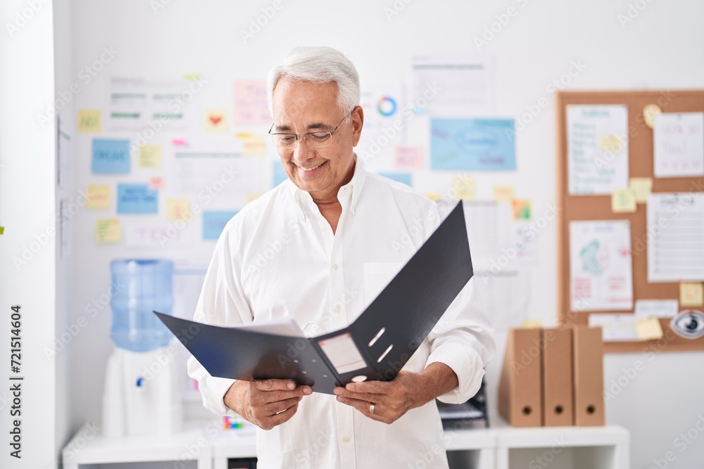 Middle age grey-haired man business worker reading document at office