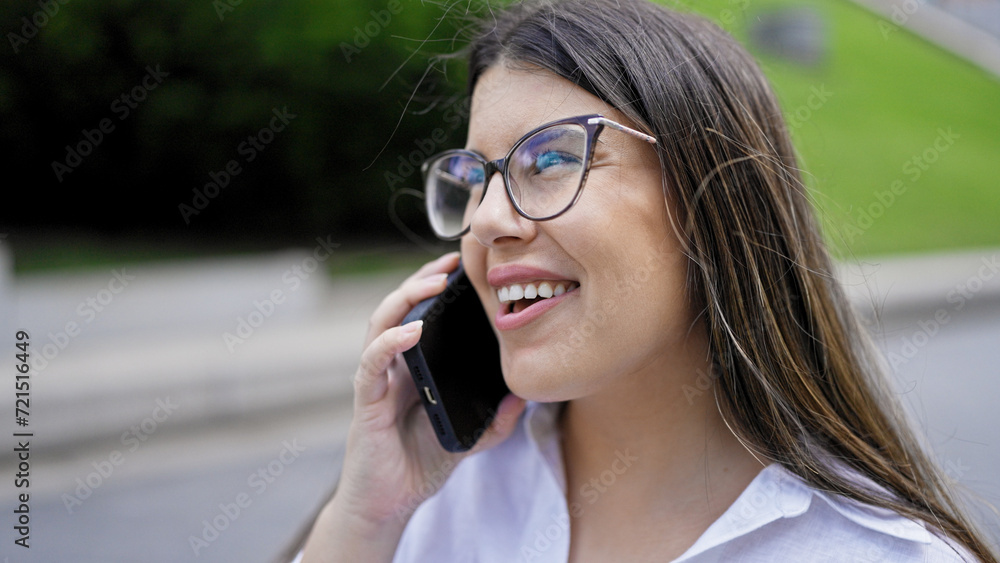 Young beautiful hispanic woman smiling happy speaking on the phone in the streets of Madrid Young beautiful hispanic woman smiling happy speaking on the phone in the streets of Madrid