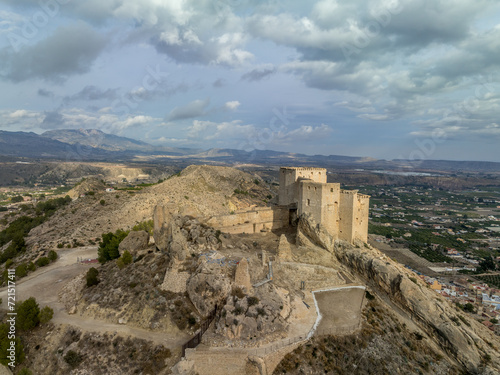 Aerial panorama view of Castillo de los Velez  medieval ruined castle perched on top of Mula  keep  well tower  machicolation  Parroquia Mayor De Santo Domingo De Guzm  n church  