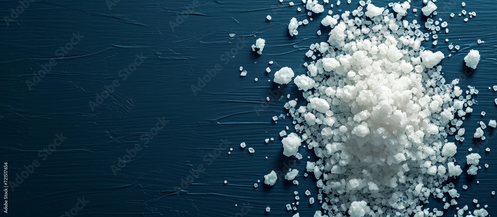 Obraz premium Salt Concept on Dark Blue Background: Enhancing the Salty Experience with a Captivating Concept on a Moody Dark Blue Background