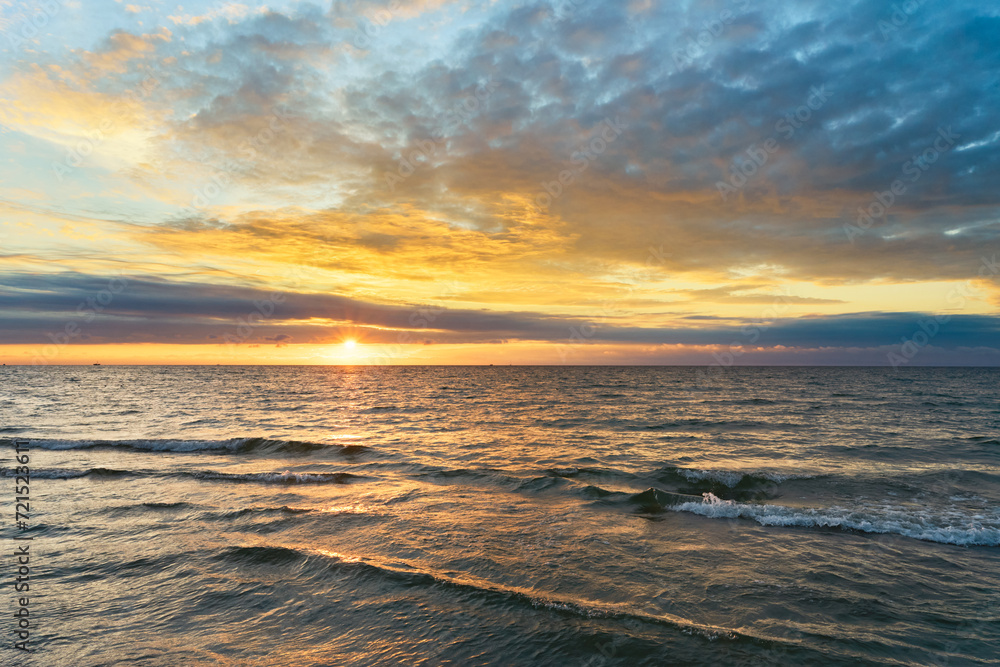 Sunset on Baltic Sea white bright golden orange color and calm sea	
