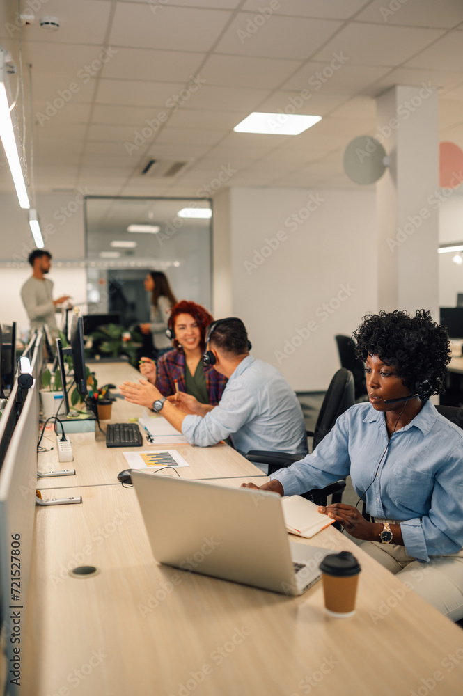 A customer support agents sitting at call center and talking to clients.