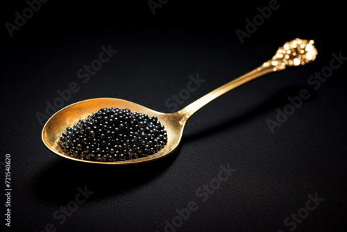 Extreme close up of a golden spoon with black caviar. Beautiful light and glare on fish eggs