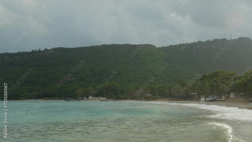 Overcast, cloudy weather over hills with dense forests, waves on the sea. Overcast, cloudy weather over hills with dense forests, waves on the sea.