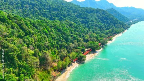 Azure sea washes up on idyllic beaches adorned with luxurious resorts. Verdant mountains rise majestically, embraced by a flawless blue sky. A mesmerizing drone's view. Trat Province, Thailand. 4K.
 photo