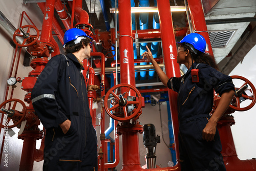 Male and Female engineer working in fire extinguishing room , extinguishing piping system