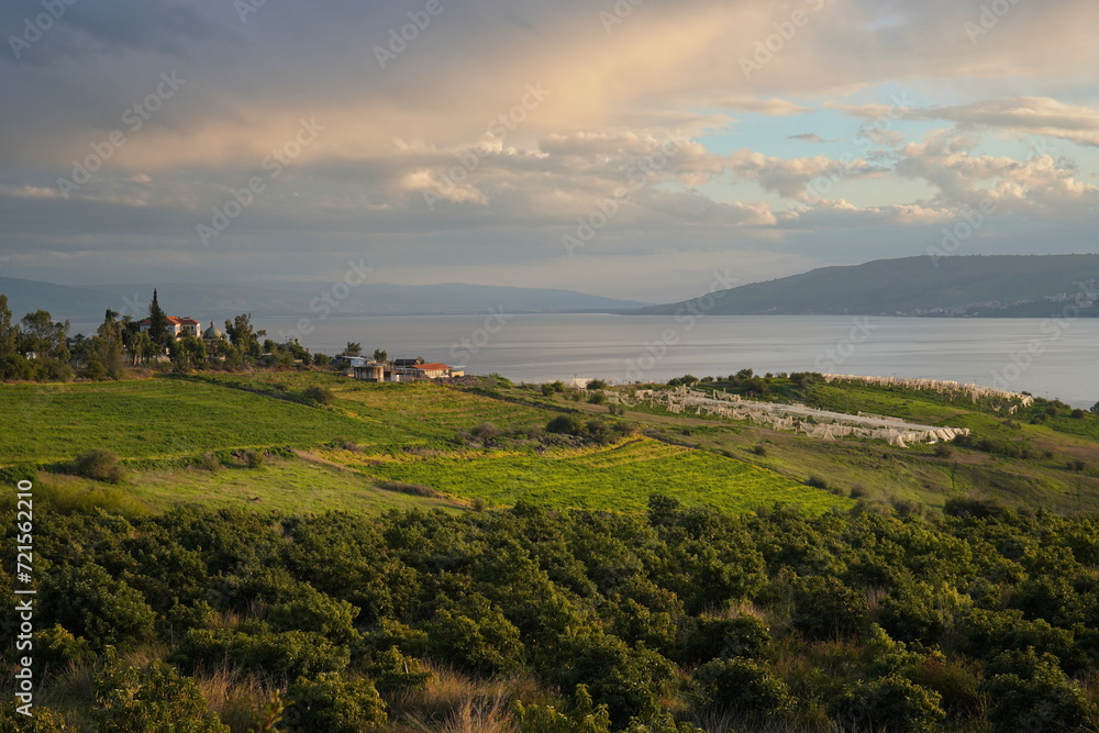 view of Sea of Galilee or Kinneret lake and Church of Beatitudes at sunset in the winter in Northern Israel. 