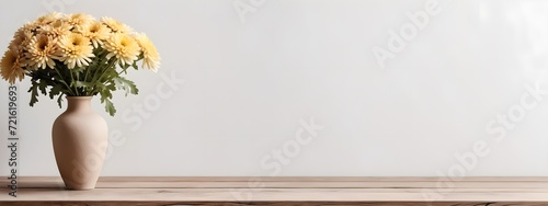 Wooden table with beige clay vase with bouquet of chrysanthemum flowers, blank white wall. Home interior background with copy space.