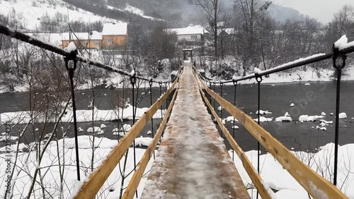 Ukraine, the Carpathian fog in the mountains has enveloped the pedestrian rope bridge over the Latoritsa River, the warm winter of Transcarpathia gives either rain or snow photo