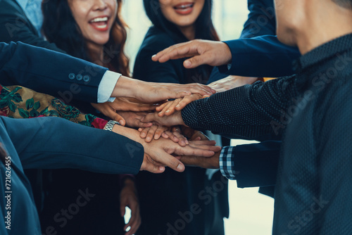 A group of diversity people putting their hands together. Showing unity teamwork and friendship. Close up side view of young business man and business woman joining as a team. Intellectual. photo