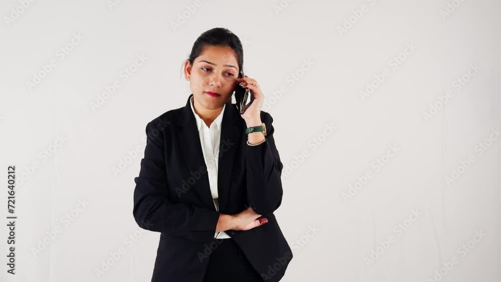 Focused smiling business woman using smart phone taking call against a white background Focused smiling business woman using smart phone taking call against a white background