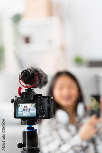 Vertical photo of a chinese blogger recording an online video at home