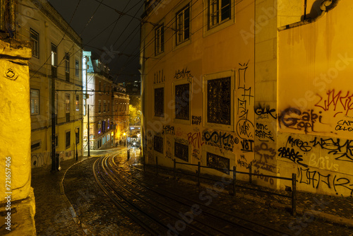 Street view of historical funicular Elevador da Gloria waiting to leave uphill during a night time, Lisbon, Portugal