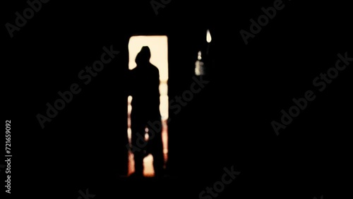 a man with a knife comes out of the door