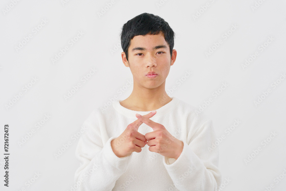 指でばつ印のジェスチャーをする男の子 白背景 指でばつ印のジェスチャーをする男の子 白背景