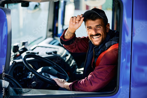 Happy driver behind steering wheel of truck looking at camera. photo