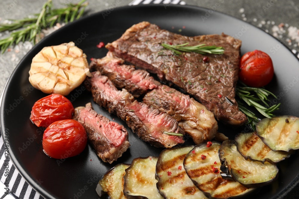 Delicious grilled beef steak with vegetables and spices on table, closeup Delicious grilled beef steak with vegetables and spices on table, closeup