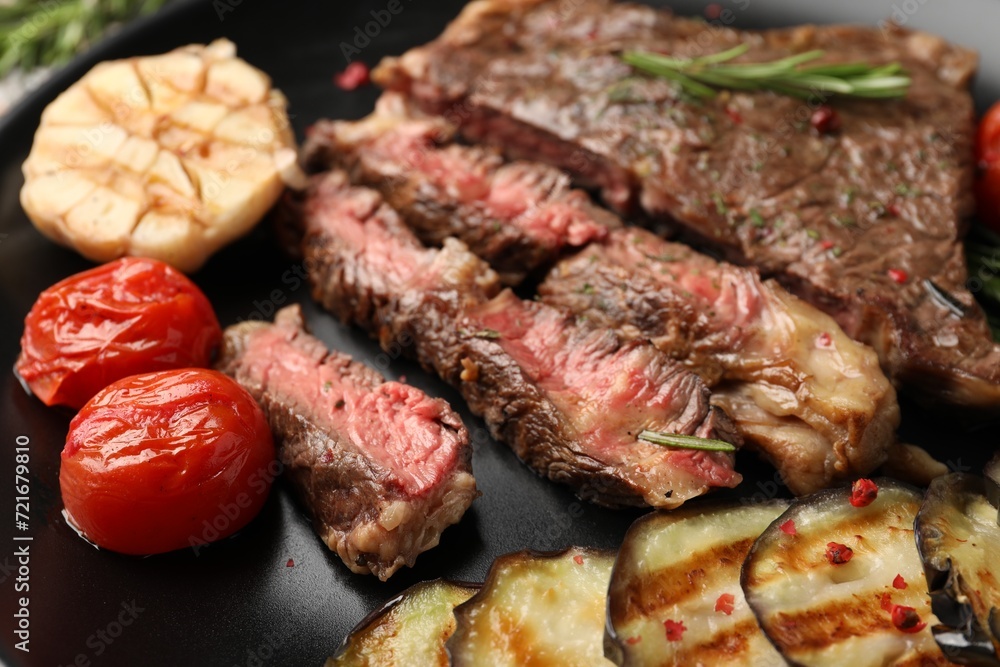 Delicious grilled beef steak with vegetables and spices on plate, closeup