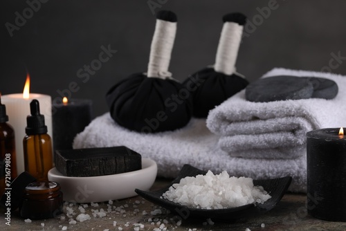 Composition with different spa products and burning candles on grey table
