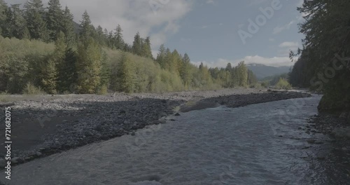 Ungraded 4k wide-angle low altitude pullout drone footage flying above the Nisqually River on a sunny morning at Gifford Pinchot National Forest in Washington State. photo