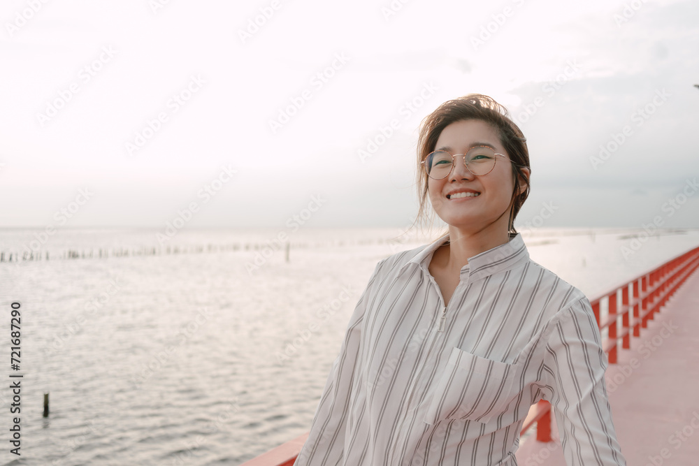 Happy Asian woman walking along red bridge for chilling and sightseeing. Happy Asian woman walking along red bridge for chilling and sightseeing.