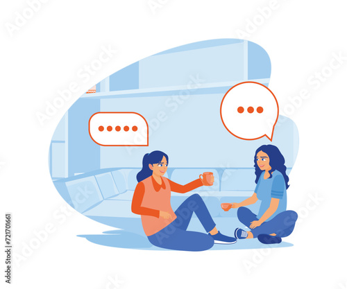 Two young women are discussing while drinking tea together. They sat on the floor in front of the sofa. Smiling woman friends drinking tea at home concept. Flat vector modern illustration.