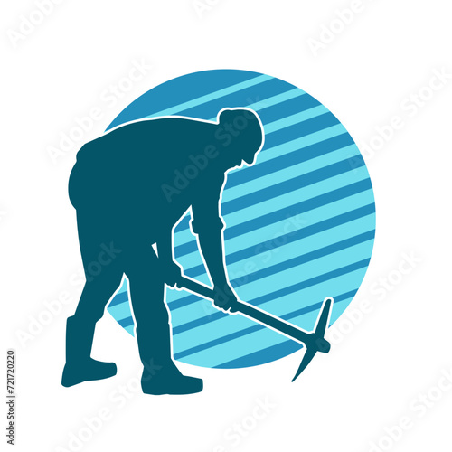 Silhouette of a man in worker costume carrying pick axe tool in action pose. Silhouette of a miner in action pose with pick axe tool.