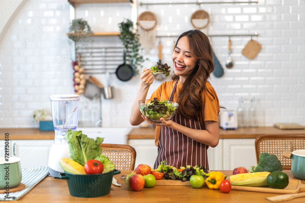 Portrait of beauty body slim healthy asian woman eating vegan food healthy with fresh vegetable salad in kitchen at home.diet, vegetarian, fruit, wellness, health, green food.Fitness and healthy food Portrait of beauty body slim healthy asian woman eating vegan food healthy with fresh vegetable salad in kitchen at home.diet, vegetarian, fruit, wellness, health, green food.Fitness and healthy food