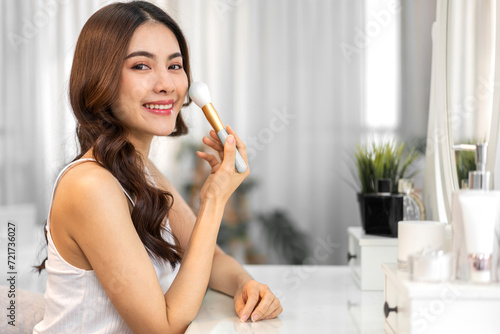Smiling beautiful asian woman fresh healthy white skin  clean  looking at mirror.asian girl touching on face applying cream  skincare  cosmetics  cosmetology  beauty  fashion at home.spa and wellness