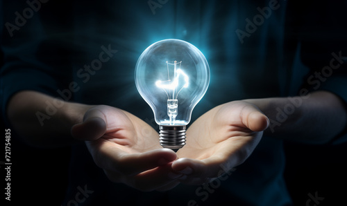 Hands of man holding illuminated light bulb, front view with copy space