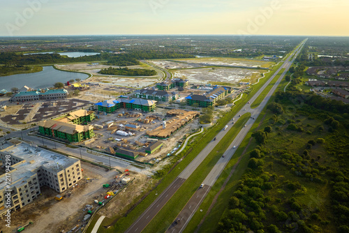 Fototapeta Naklejka Na Ścianę i Meble -  New apartment buildings under construction in american rural area near state highway. Development of residential housing in US suburbs. Real estate market in the USA