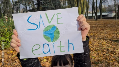 Save Earth poster in park in children hands Climate strike and demonstration photo