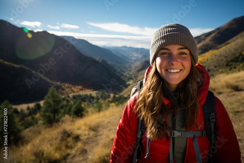 A wide-angle shot of a teenage girl in adventurous outdoor gear, discovering a picturesque trail in the mountains. Use natural light to highlight the rugged beauty of the landscape. © Kuo