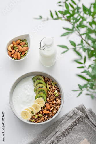 Wallpaper Mural Granola with banana and kiwi on a white table with a green branch. Torontodigital.ca