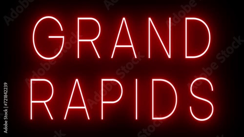 Flickering red retro style neon sign glowing against a black background for GRAND RAPIDS photo