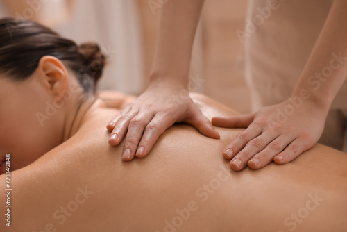 Woman receiving back massage in spa salon, closeup