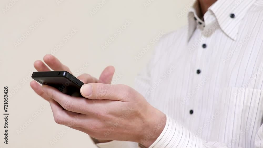 スマートフォンを操作する白いワイシャツ姿の男性 スマートフォンを操作する白いワイシャツ姿の男性