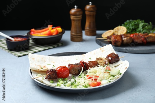 Delicious shish kebab with vegetables served on gray table, closeup