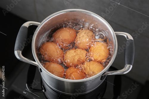 Chicken eggs boiling in pot on electric stove, above view © New Africa